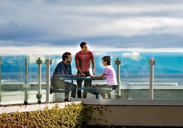 Students talking together with an ocean view behind them